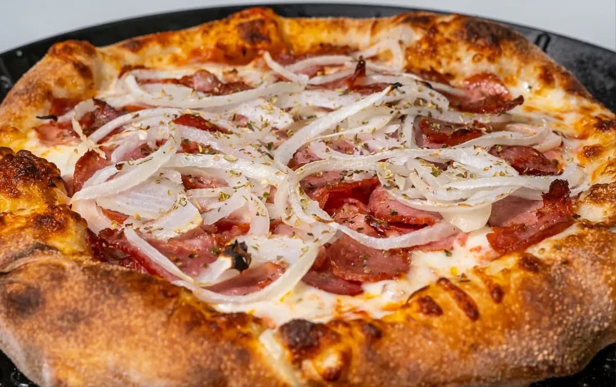 A Brasiliana pizza topped with ham and onion