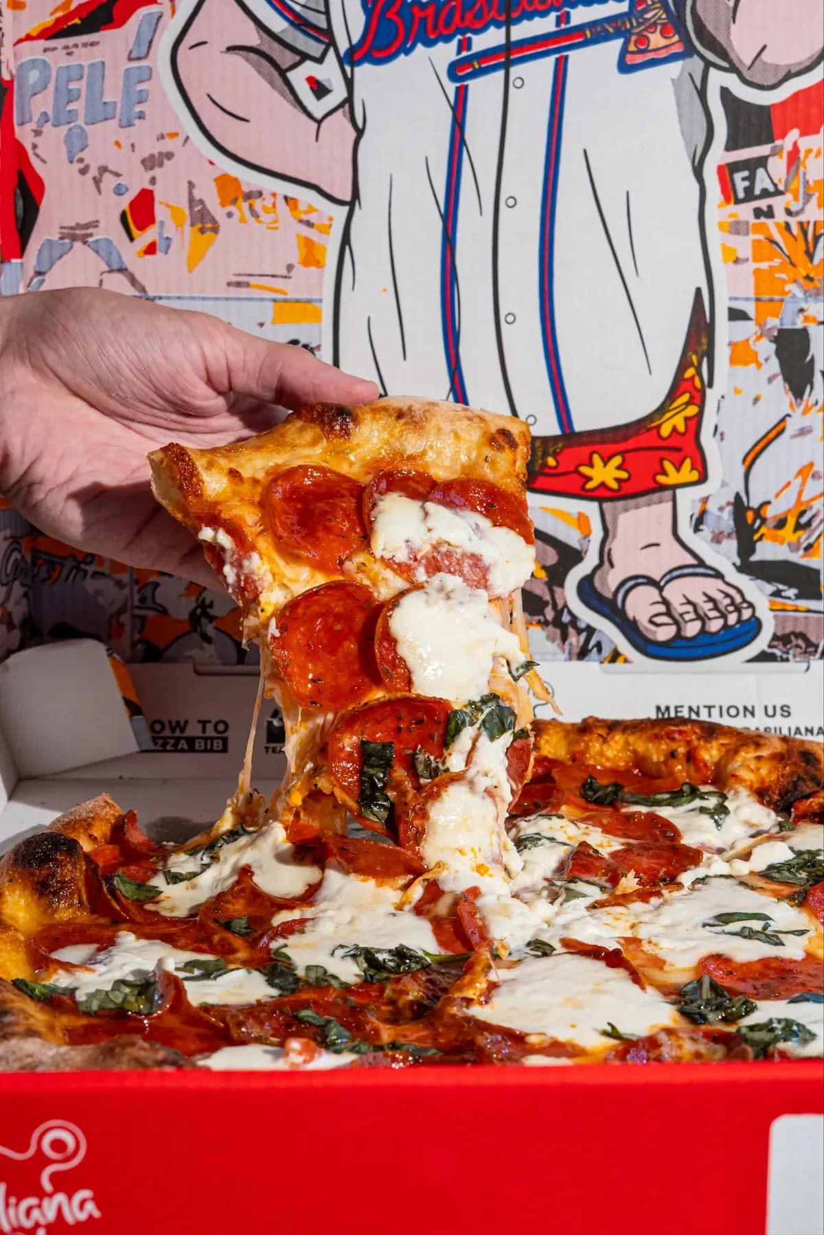 A cheesy slice being lifted from a Brasiliana pizza